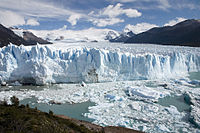 A tourist yatch near a glacier wall